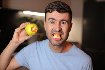 Man with bloody gums after bitting an apple