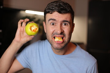 Man with bloody gums after bitting an apple 