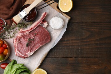 Flat lay composition with raw meat, thyme and marinade on wooden table. Space for text