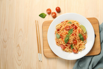 Vegetarian meal. Tasty pasta with fresh tomatoes and basil on wooden table, flat lay. Space for text
