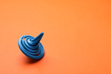 One blue spinning top on orange background