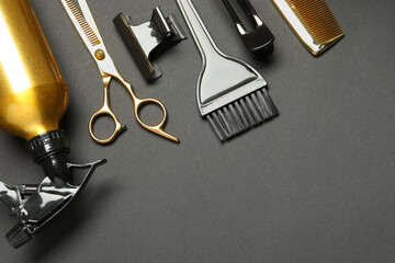 Hairdressing tools on dark table, flat lay. Space for text