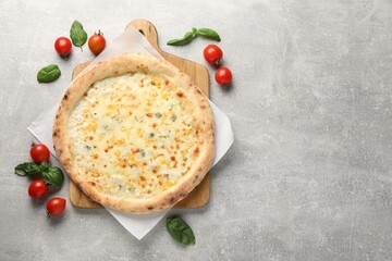 Delicious cheese pizza, basil and tomatoes on light grey table, flat lay. Space for text