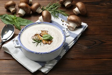 Delicious homemade mushroom soup served on wooden table. Space for text