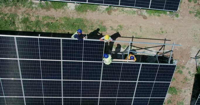 A solar panel field with a man working on instalation. Scene is hard work and dedication to renewable energy
