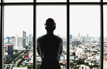 silhouette back view architect man looking out of glass window in city - obrazy, fototapety, plakaty