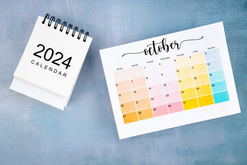 October 2024 calendar page with on wooden background.