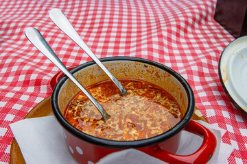 Traditional Slovak Ukrainian Russian cabbage soup with sausage and smoked meat served in retro red...