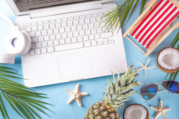 Work and vacation. Creative summer beach office flat lay with white laptop, tropical summer...