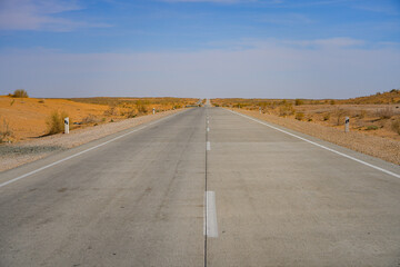 Symmetric view of the A380 highway passing through the Kyzylkum Desert, Khorezm, Uzbekistan,...