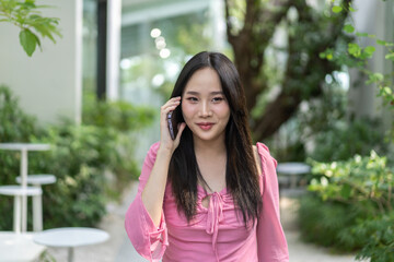 Asian cheerful woman enjoys a lively conversation on his mobile phone, modern communication, the joy of connection, and the simplicity of daily life,technology in everyday life