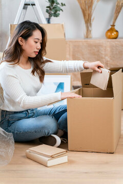Woman unpacking a cardboard box at home