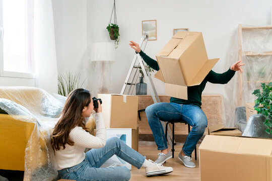 Person tripping while carrying boxes as another person watches