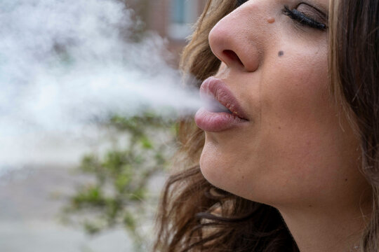 Close-up of a woman exhaling smoke
