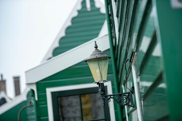 Street lantern mounted on a green wooden facade