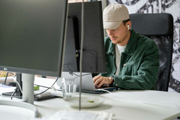 Man working intently at a dual monitor computer setup