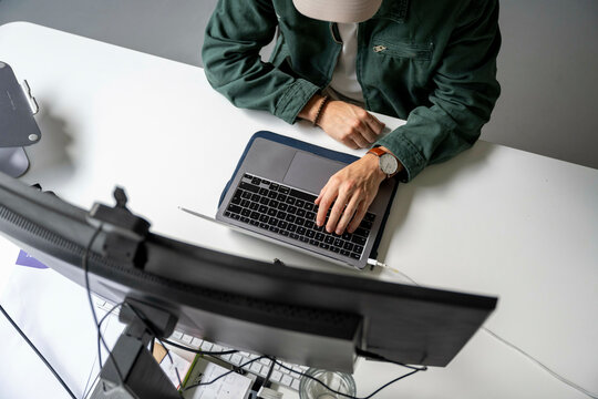 Man using laptop at a modern workspace - Powered by Adobe