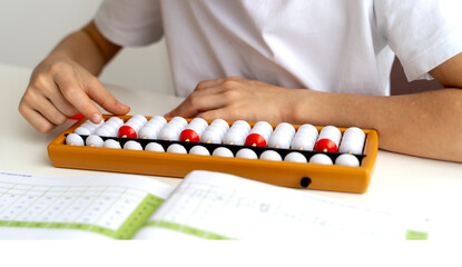 boy student doing mental arithmetic on the abacus