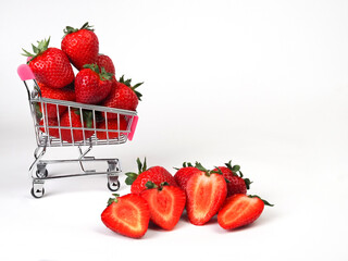 small shopping cart with strawberries on white background