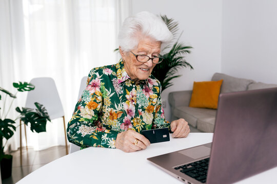 Elderly woman using laptop for online shopping at home