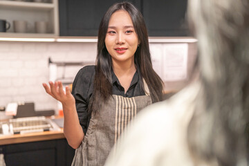 Portrait of asian barista woman small business owner working behind the counter bar and  receive...