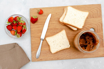 Sandwich toast bread with peanut butter, strawberry,nuts on cutting board. kids childrens baby's sweet dessert, healthy breakfast,lunch, food art on gray background,top view,flatlay