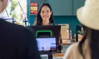 Portrait of asian barista woman small business owner working behind the counter bar and  receive order from customer on coffee packaging and cup of coffee background in cafe or coffee shop