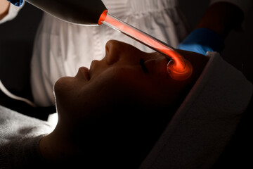 Woman lying on a beauty procedure with a microcurrent cosmetic tools in a salon