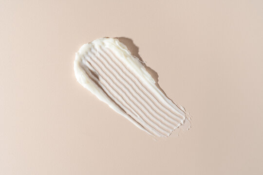Textured Swipe of White Cream on a Neutral Background