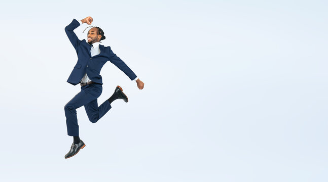 Full body photo of a Black male business person jumping. (We also sell PNGs that are cropped and have transparent background. Please search for "PNG" from the creator link.)