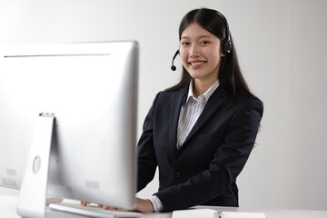 Telephone operator works with computer in office and talks with customers.