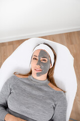Woman with face mask on her face lying on a couch in a beauty salon
