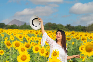 Happy young woman enjoying in yellow  sunflower field. Lifestyle Concep