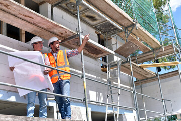 construction manager and architect on site during the construction of a house - planning and control on site - teamwork