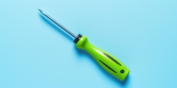 A green screwdriver laying on a blue surface. Can be used for DIY projects