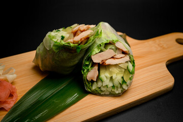 Demonstration foto of rolls with cucumbers and fillet on a wooden board