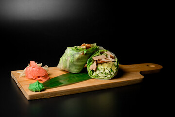 Appetite rolls with fillet and green vegetables on a wood stand