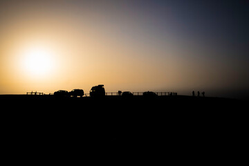 Silhouette of cars and people on the Cordoama viewpoint in Vila do Bispo, Algarve, enjoying a sunset.