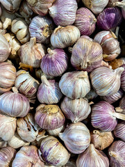 stack of raw garlic in plastic container in market. Top view