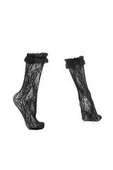 Close-up shot of black lace trim knee high socks. The pair of black lace ruffle knee high socks is isolated on a white background. Side view.
