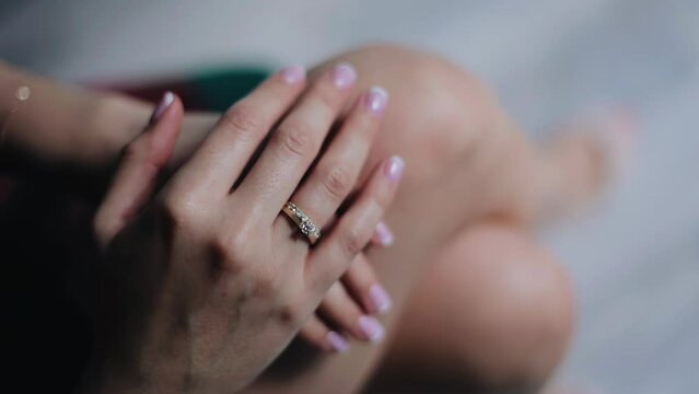 The girl touches the ring on her hand. She gently moves it right on her finger. Close-up shooting