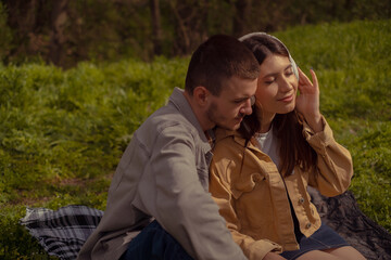 A young couple listens to music by the lake. Tourist attractions and scenic spots, hiking trails...