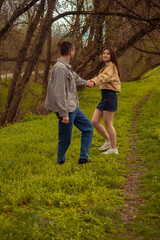 Obraz premium A young couple whirl and dance in the forest, teenage romantic relationship and friendship Valentine's Day