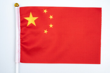 A China flag against white background. The national flag of the People's Republic of China is red in color, rectangular in shape, with five stars.