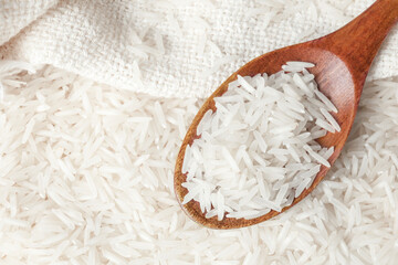 Raw basmati rice and spoon, top view. Space for text