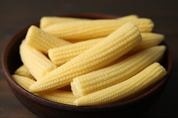 Tasty fresh yellow baby corns in bowl on table, closeup