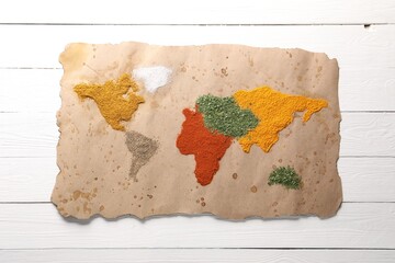 World map of different spices on white wooden table, top view