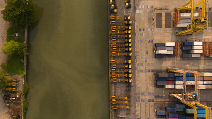 Top view of riverside with container ship in import export business logistic by crane ,Bangkok Trade Port, Thailand