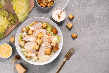 Chicken Caesar Salad in a Bowl with Parmesan Cheese, Dressing and Croutons
