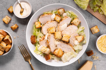 Chicken Caesar Salad in a Bowl with Parmesan Cheese, Dressing and Croutons